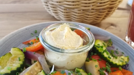 Teller mit Dip und gegrilltem Gemüse, daneben Brotkorb mit Semmel und Brezel.