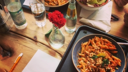 Gedeckter Tisch mit Pasta und Salat.