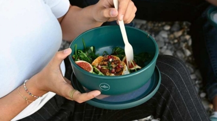 Frau hält Rebowl-Schüssel mit Salat.